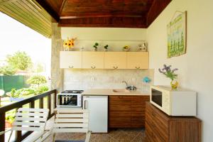 a kitchen with a balcony with a stove and a microwave at Villa Yanevi in Lozenets +29 photos