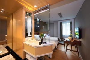 a bathroom with a large mirror and a large tub at Kingwood Boutique Hotel in Miri
