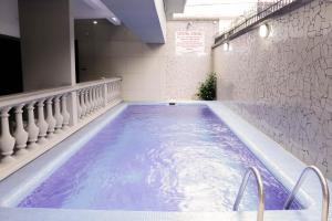 a swimming pool with purple water in a building at Tchero Appartement 2 in Douala
