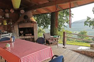 a table and chairs on a deck with a fireplace at Stonehouse in Nova Gorica