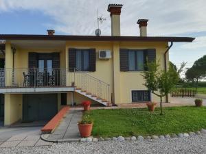 a yellow house with a balcony and a yard at Villa Delux in Correzzola
