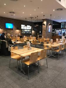 un restaurante con mesas y sillas de madera y gente sentada en 96 North Terrace en Adelaida