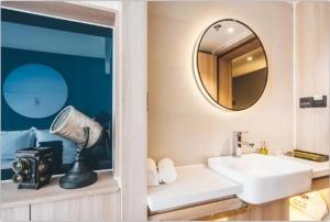 a bathroom with a sink and a mirror at Atour Light Hotel Tangshan Exhibition Center in Tangshan
