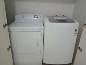 a refrigerator and a washer and dryer in a room at Plumeria Garden in Saipan