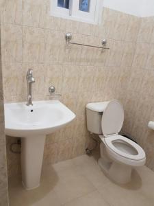 a bathroom with a toilet and a sink at Plumeria Garden in Saipan