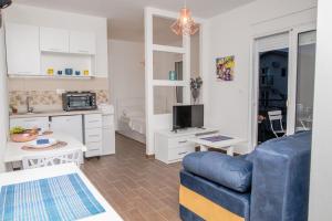 a living room with a blue couch and a kitchen at Apartments Tina in Utjeha