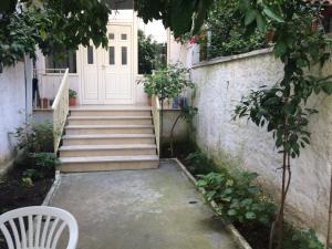 a stairway leading to a white door with a white chair at Nina Guest House in Tirana