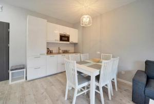 a kitchen and dining room with a table and chairs at Apartamenty Sun Seasons 24 - Gondola in Świeradów-Zdrój