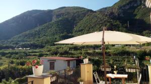 a patio with an umbrella and mountains in the background at Annabella's Country House in SantʼAntonio Abate