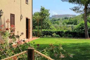 a house with a yard with a green lawn at Agriturismo Pimpinnacolo in Porto Ercole