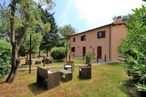 a group of benches in a yard next to a building at Agriturismo Pimpinnacolo in Porto Ercole