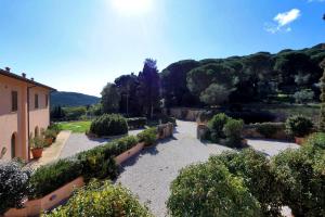 a garden with bushes and trees and a building at Agriturismo Pimpinnacolo in Porto Ercole
