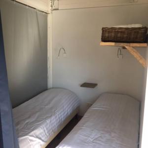 een slaapkamer met 2 bedden in een kamer bij Safaritent glamping tent nabij Sint Maartenszee in Sint Maartensvlotbrug