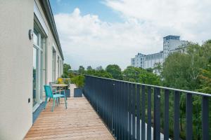 a balcony with a table and chairs on a building at Park Penthouses Insel Eiswerder in Berlin