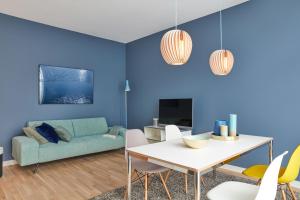 uma sala de estar azul com uma mesa e um sofá em Park Penthouses Insel Eiswerder em Berlim