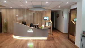 an office with a reception desk with two chairs at Logis Des Trois Massifs in Claix