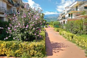 マスカリにあるSicilia Etna Mareの一部の建物の前に花々が咲く遊歩道