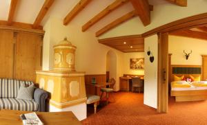 a living room with a couch and a bedroom at Berghotel Mühle in Bad Hindelang