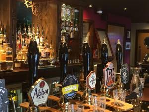 een bar met flessen alcohol op een tafel bij Greyfriars Inn by Greene King Inns in St Andrews