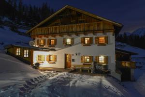 a large house in the snow at night at Berghütte Schöpf in Umhausen