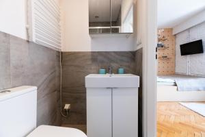 a bathroom with a white toilet and a sink at Apartament w sercu miasta in Łódź +47 photos