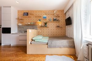 a bed in a room with a wall with shelves at Apartament w sercu miasta in Łódź