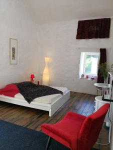 Saint-Jean-et-Saint-Paul的住宿－德高塔姆紅磨坊住宿加早餐旅館，一间卧室配有一张床和一张红色椅子