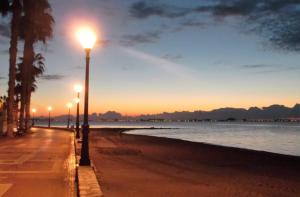 a row of street lights on a beach at sunset at Beautiful 3 bed, 2 bath modern apartment in Los Alcázares