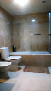 a bathroom with a toilet and a shower and a tub at Beautiful 3 bed, 2 bath modern apartment in Los Alcázares