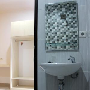 a bathroom with a sink and a mirror on the wall at Rumah99 in Jakarta