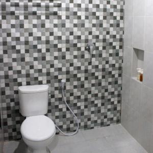 a bathroom with a toilet and a shower at Rumah99 in Jakarta +6 photos