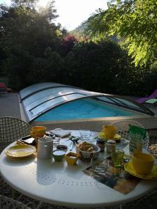 a table with food on it next to a swimming pool at Le Moulin de Gauty in Saint-Jean-et-Saint-Paul