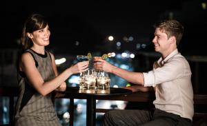 a man and woman sitting at a table with drinks at Salana Boutique Hotel in Vientiane