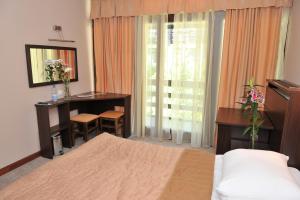 a bedroom with a bed and a desk and a table at Hotel Radan Prolom Banja in Prolomska Banja