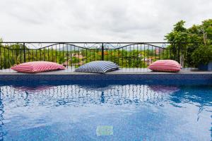 three pillows are sitting next to a swimming pool at The Bridge Residence Hotel in Kanchanaburi