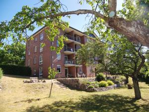ein großes rotes Backsteingebäude mit einem Baum davor in der Unterkunft Haus Roland- Whg 23 mit Schwimmbad und Sauna in Zinnowitz