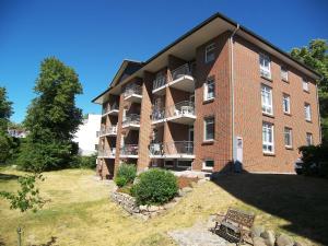 ein großes Backsteingebäude mit einer Rasenfläche davor in der Unterkunft Haus Roland- Whg 23 mit Schwimmbad und Sauna in Zinnowitz