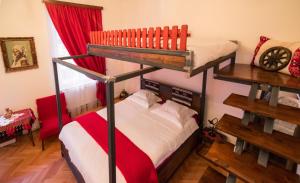 シビウにあるFolkloric Loft - Sibiul vechiの赤いカーテンが備わるドミトリールームの二段ベッド2台分です。