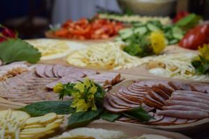 una mesa cubierta con diferentes tipos de carne y queso en Dafne Zakopane, en Zakopane