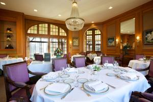 a dining room with white tables and purple chairs at Le Moulin De Connelles in Connelles