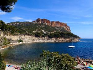 a boat in a body of water with a mountain at Chez Mamouska in Cassis