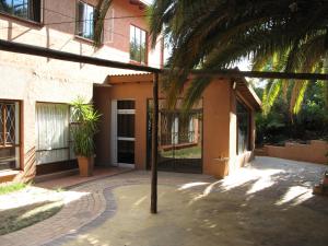 un bâtiment avec un palmier en face dans l'établissement Johannesburg Boarding Hostel, à Johannesbourg