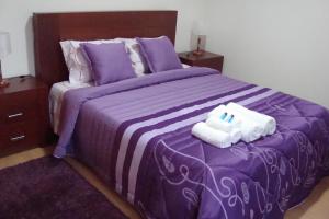 a purple bed with two towels on top of it at Casa do Nascente in Paredes do Rio