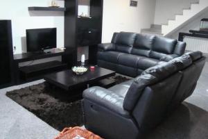 a black leather couch and a coffee table in a living room at Casa do Nascente in Paredes do Rio