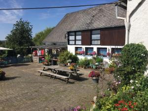 ein Haus mit einem Picknicktisch davor in der Unterkunft B&B De Eifelhoeve in Herresbach