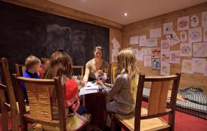 a group of children sitting around a table in a room at Chalet-Hôtel La Marmotte, La Tapiaz & SPA, The Originals Relais (Hotel-Chalet de Tradition) in Les Gets
