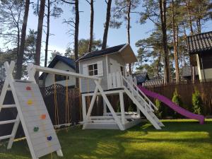 a playground with a slide and a play house at Leo Royal Home Pobierowo in Pobierowo