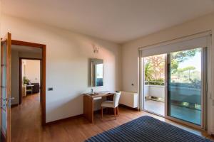 - un salon avec un bureau et une porte coulissante en verre dans l'établissement Verdeluna ApartHotel, à Marina di Pietrasanta