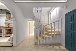 a staircase in a house with a blue door at Royal Villa Pedi in Symi