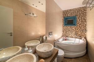 a bathroom with two sinks and a tub and a toilet at Royal Villa Pedi in Symi